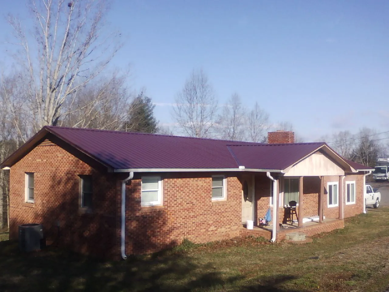 Burgundy metal roof on a brick ranch home with a new addition in Westfield