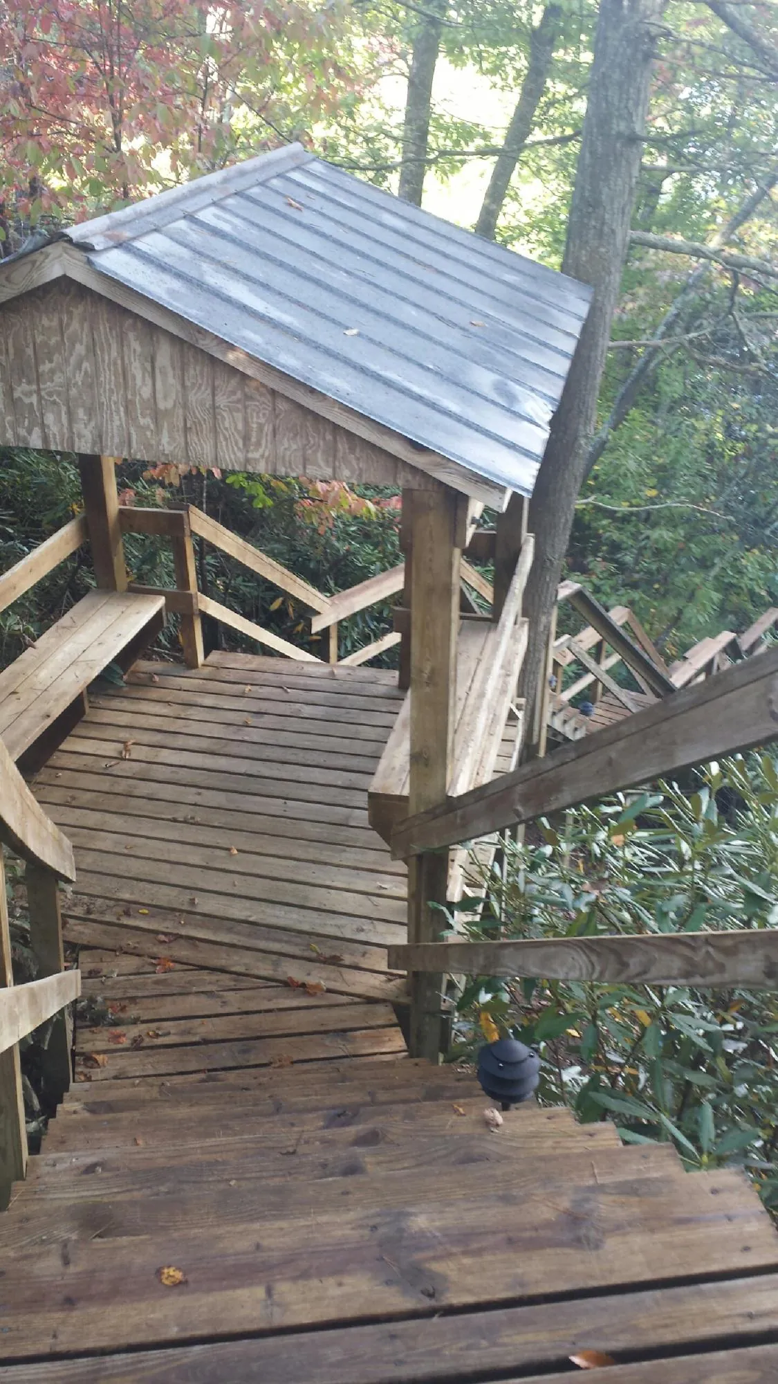 Metal roofed shelter over wooden steps on a wooded walkway — Skylight Repair & Installation work by our crew in Westfield